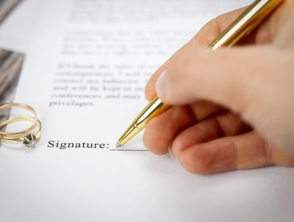 A man signs a document to file for divorce